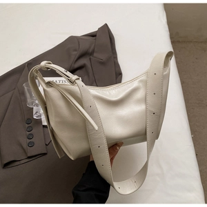 Minimalist creamy white crescent bag with soft faux leather texture and adjustable strap