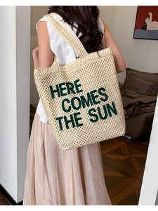 Large beige woven beach tote bag with green embroidered Here Comes The Sun slogan