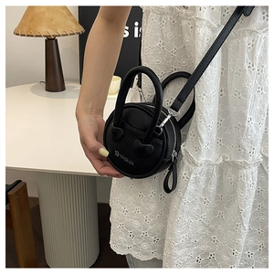 Vue détaillée d'un mini sac rond noir en cuir grainé avec poignées anneaux