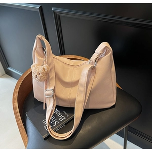 Close-up of soft pink tote bag with adjustable strap and cute brown teddy bear keychain