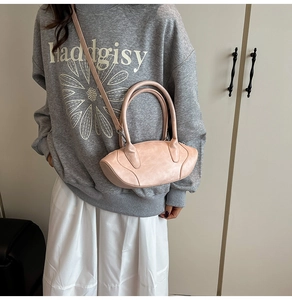 Detail of pink leather handbag showing smooth texture, slim handles and shoulder strap