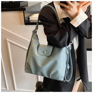 Detail of light blue lychee pattern leather tote bag with stylish folded base design