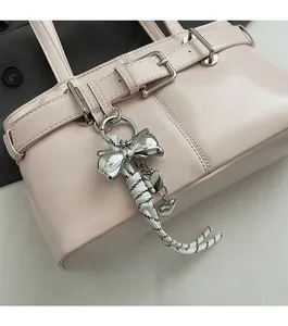 Dettaglio borsa a secchiello rosa con ciondolo a fiocco argento e cuore
