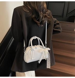 White Boston handbag with pearl lace bow detail shown on shoulder for an elegant look