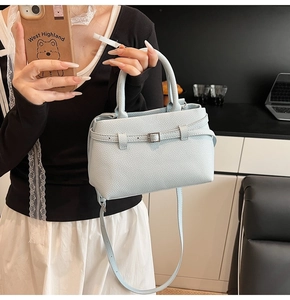Close-up of light blue lychee pattern leather handbag featuring decorative metal buckle