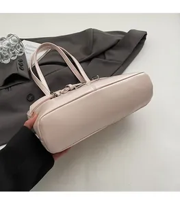 Dettaglio del fondo piatto strutturato dell'elegante borsa a secchiello rosa cipria
