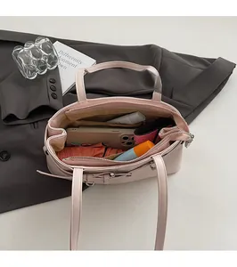 Vista dettagliata dell'ampio interno della borsa rosa con tasche e vari oggetti quotidiani