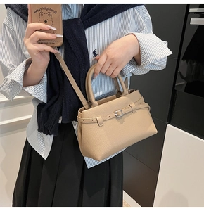 Beige pebble leather bucket bag with silver eyelet straps shown in casual lifestyle setting