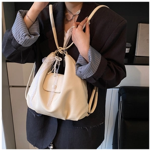 Detailed shot of white lychee leather tote bag with lace trim and pearl charms decoration