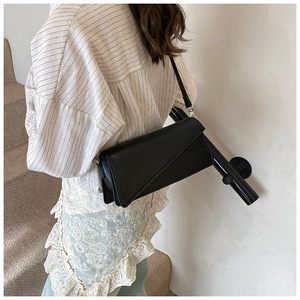 Close-up of geometric stitching on black matte baguette bag with flap cover