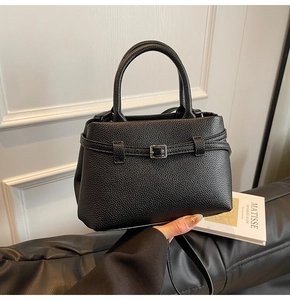 Close-up of black lychee grain leather bucket bag with silver buckle and strap