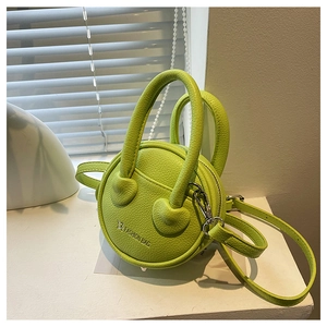 Détail d'un mini sac rond vert citron avec texture litchi et finitions métalliques argent