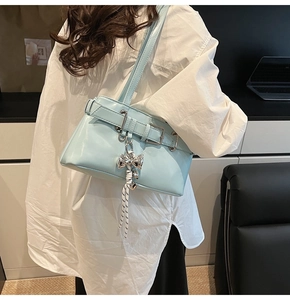 Dettaglio della borsa in pelle azzurra con fibbia d'argento e ciondolo a fiocco