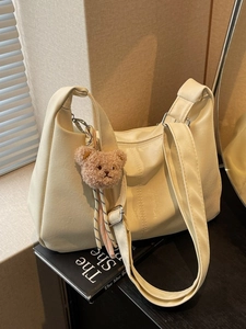 Cream hobo shoulder bag in soft pebbled leather with a cute plush bear charm