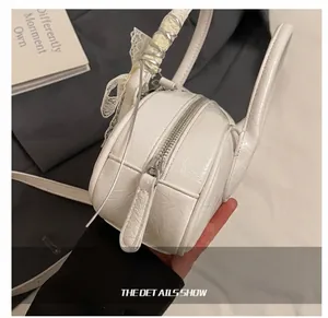 Λεπτομέρεια λευκής στρογγυλής τσάντας με δαντελωτή κορδέλα και υφή εξαιρετικής ποιότητας