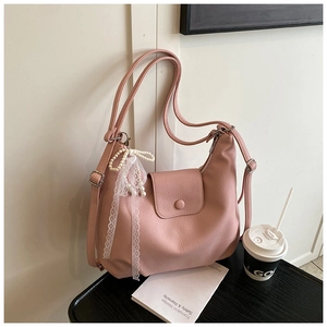 Detailed view of pink lychee leather hobo bag with lace bow and pearl accessory
