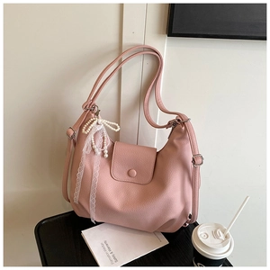 Detalle de bolso hobo rosa granulado con lazo de perlas y cinta de encaje
