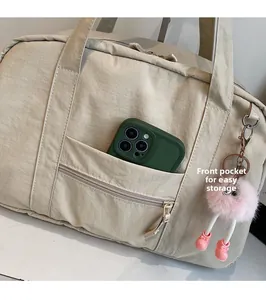 Front zipper pocket of beige canvas tote bag showing storage space for a smartphone