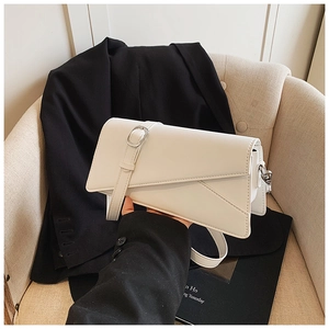 Detail of white minimalist crossbody bag with diagonal flap design and silver hardware