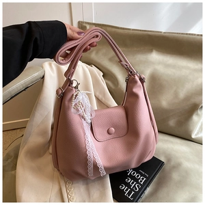 Detalle de bolso tote rosa con textura de cuero lichi y colgante de perlas fino