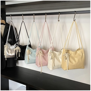 Détail de sacs en cuir verni brillant avec dentelle et pendentifs cœur en perles variés