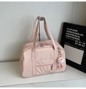 Pink large travel bag detail with double handles and cute plush charm on front pocket