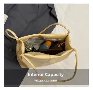 Vue de dessus du sac beige en PU montrant l'intérieur spacieux avec doublure et poche