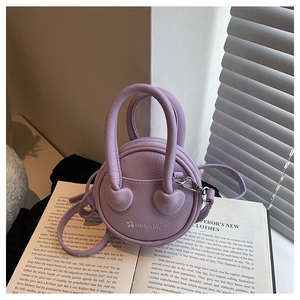 Détail du mini sac en cuir lavande avec décor cœur et lettrage du logo argenté