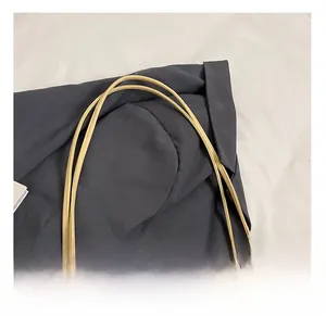 Détail des doubles bandoulières confortables et du pendentif perle sur le sac crème