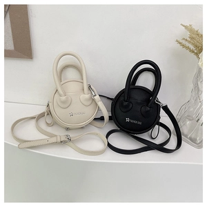 Détail de mini sacs ronds en cuir beige et noir avec logo étoile et poignées circulaires