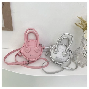 Détail de sacs à main ronds roses et argentés avec attaches de poignée en forme de cœur