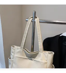 Detail view of beige textured tote bag showing side pocket and wrinkled leather material