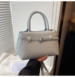 Detailed macro view of the light blue lychee pattern leather and silver metal buckle