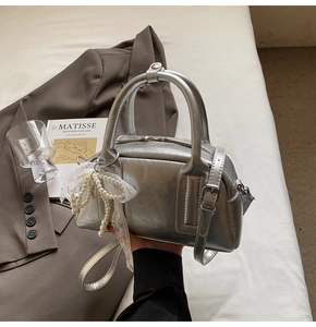 Silver metallic Boston bag featuring pleated texture and pearl lace bow charm detail