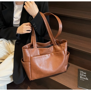 Brown leather tote bag featuring side pockets and detailed soft pleated texture details