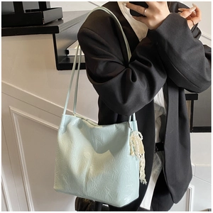 Sac à bandoulière plissé bleu clair avec breloque perle et dentelle porté par un mannequin