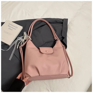 Detalle del bolso rosa con cinta de encaje de perlas y cierre de botón a presión