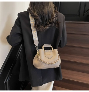 Detail of lychee pattern leather bucket bag with gold ring handle and embroidery strap