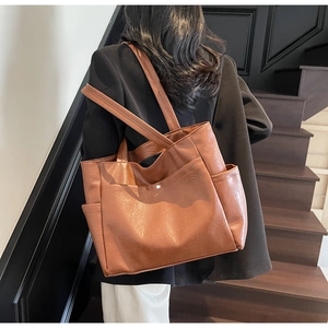 Brown soft leather tote bag detail with functional side pockets and vintage texture