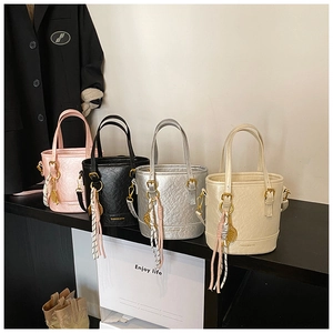 Chic bucket bags in pink, silver, and black with pleated leather and tassel detail