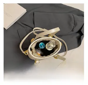 Interior view of beige bucket bag showing storage capacity for cosmetics and perfume