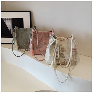 Detailed embroidery of Chinese style crossbody bucket bags in green, pink and beige silk