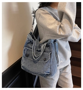 Detail der blauen Denim-Tragetasche mit zwei Klapptaschen und verstellbarem Schultergurt