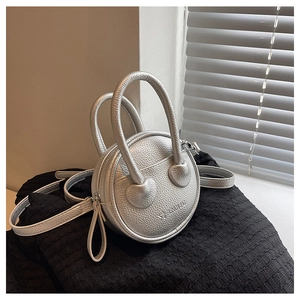Detail of silver round handbag in lychee pattern PU leather with twin handles
