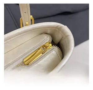 Detailed close-up of smooth gold zipper and premium leather texture on bucket bag