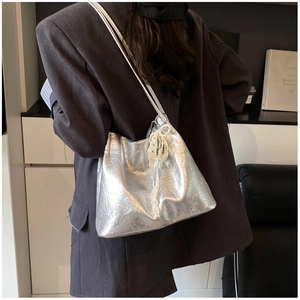Détail du sac cabas argenté métallisé avec breloque perle et dentelle sur modèle