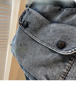Detailaufnahme der Umhängetasche aus Denim mit Klappentasche und schwarzen Knöpfen