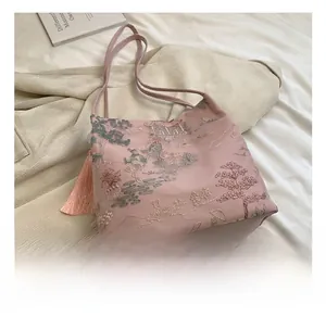 Detail of pink satin tote with traditional Chinese mountain embroidery and tassel