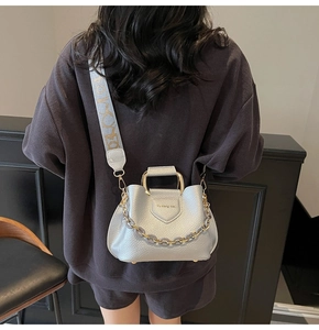 Detailed view of silver lychee leather bucket bag with gold handle and chain strap