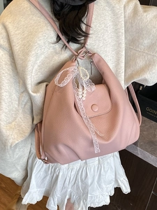 Mochila rosa de mujer en cuero granulado con lazo de encaje blanco y colgante de perla